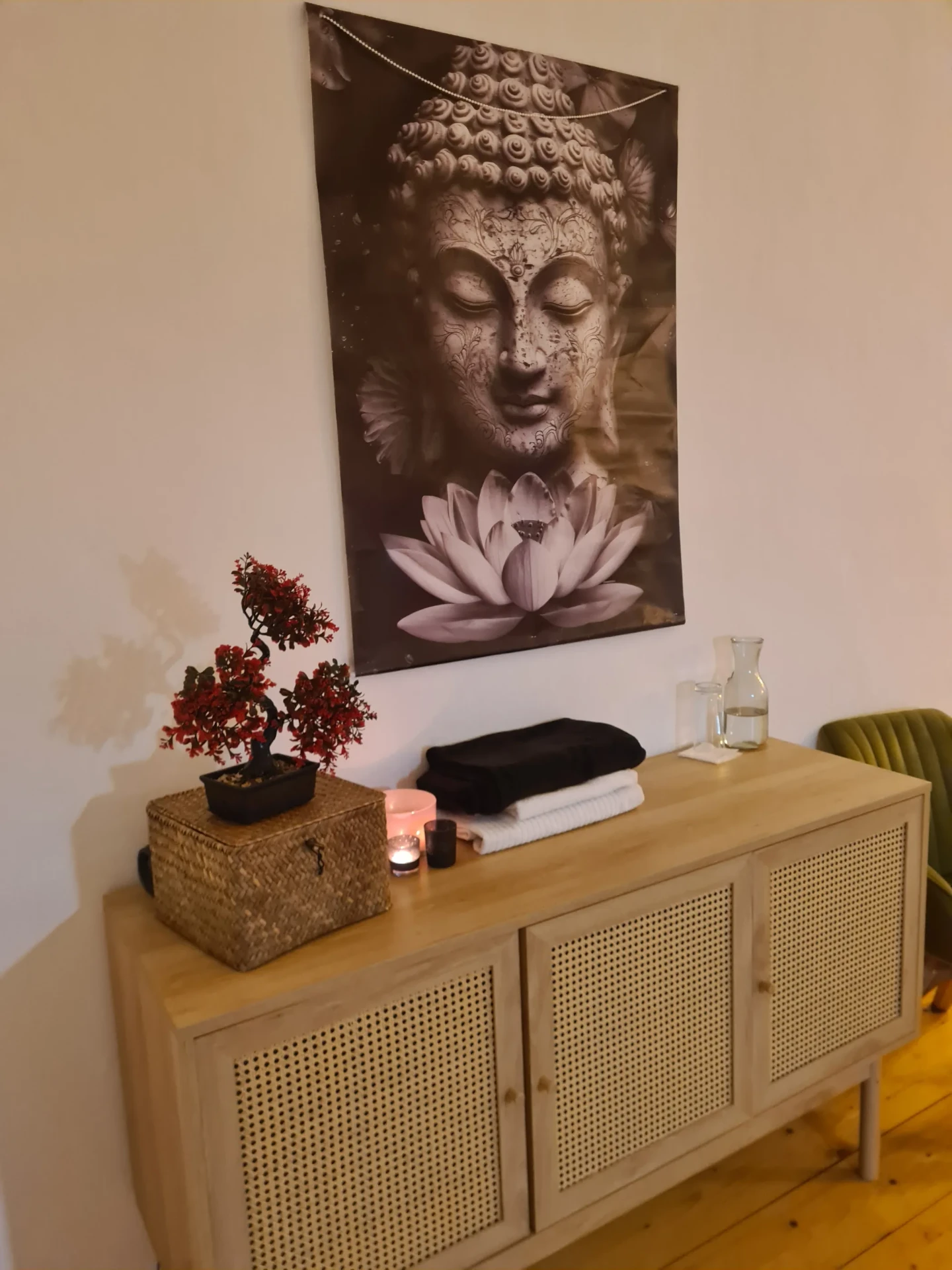 Buddha-Bild und Bonsai über einer Holzkommode